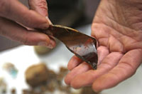 Neil Norman holds artifact from excavations in photo by G.M. Andrews, Press-Register