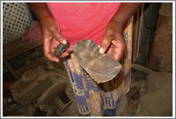 potter holding a calabash for scraping and a polishing stone for smoothing